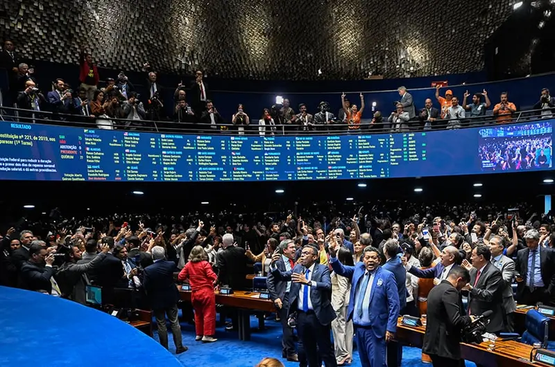 Senadores comemoram no plenário do Senado diante do painel com o resultado da votação